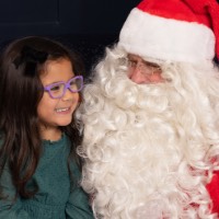 Little girl smiling and so happy on Santa's lap